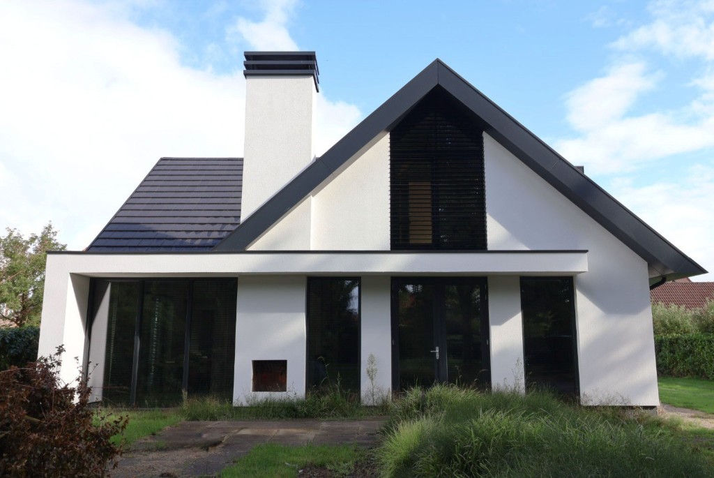 Witte woning met zadeldak en schoorsteen